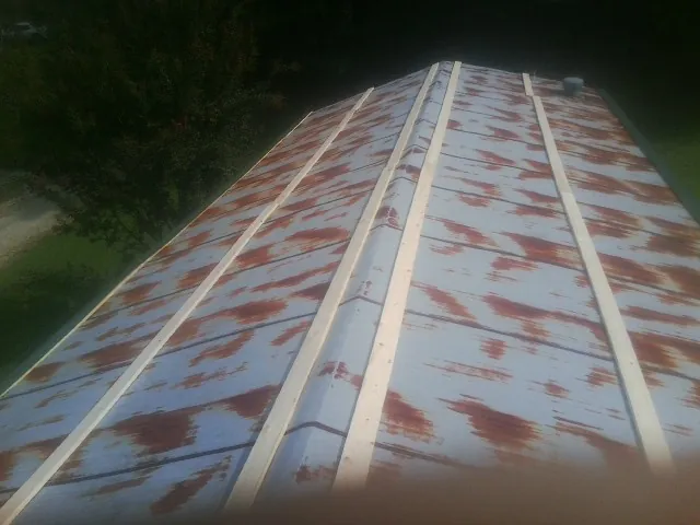 Rusted metal roof panels with new wood purlins before replacement — Storm Damage Roof Repair in Saint Hilaire by Roofing Brothers