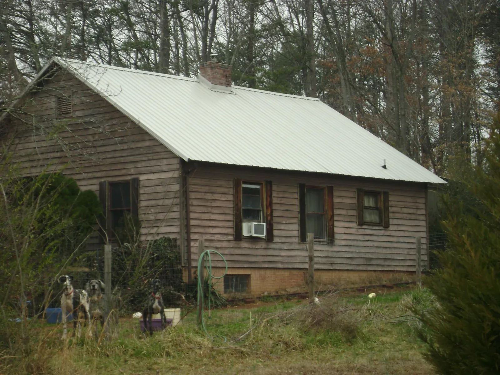 White metal roof on an old wood sided farmhouse, from a Metal Roof Installation job in Saint Hilaire